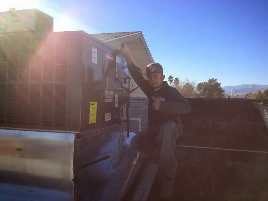 HVAC technician performing Boiler Repair on a rooftop unit in Gantt